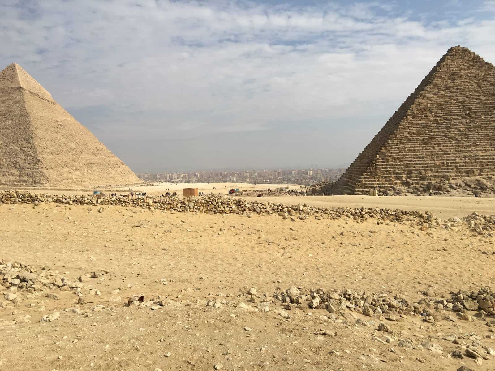 The Pyramids of Giza in the foreground with the city of Cairo in the bacground.