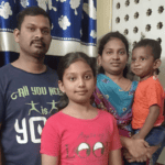 The Raj family – Arokiya, Maria, Andrea, and Joshua Daniel standing together in their home.