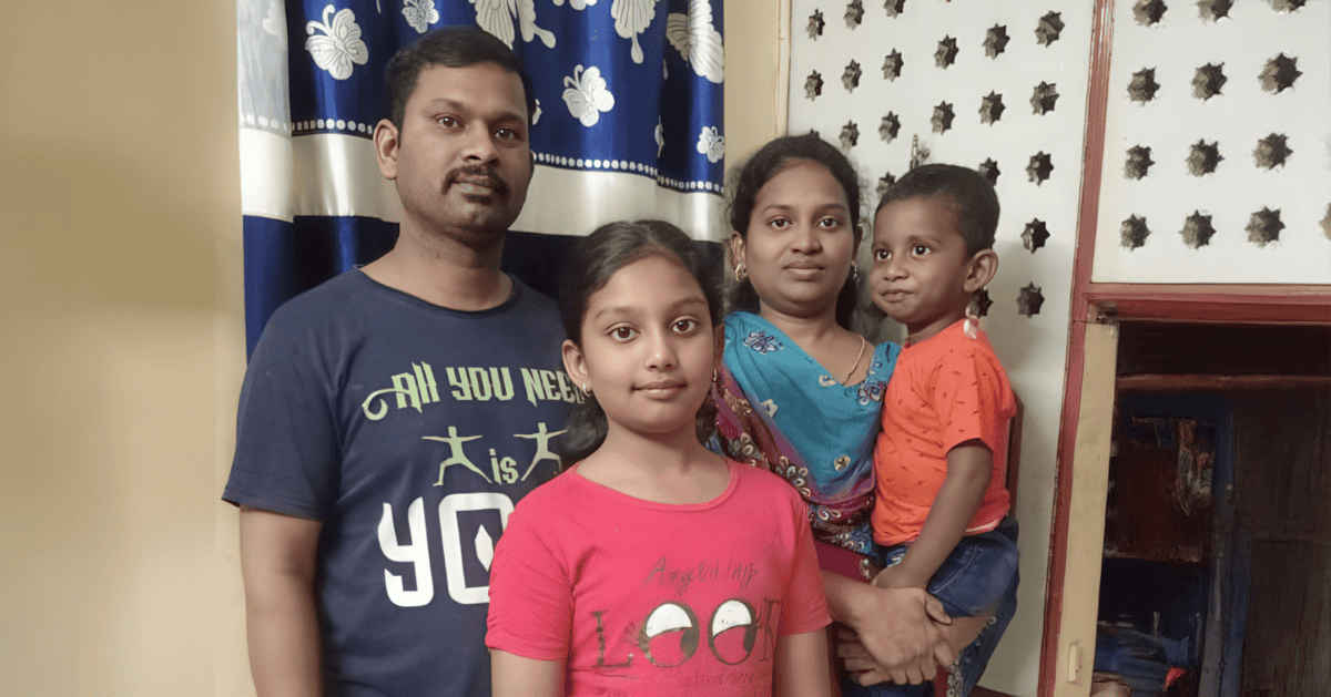 The Raj family – Arokiya, Maria, Andrea, and Joshua Daniel standing together in their home.