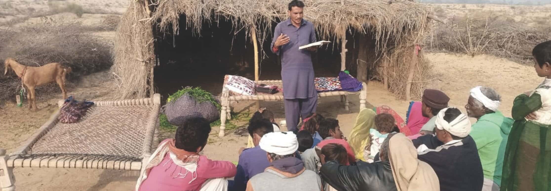 A man is giving a sermon to a group of people.